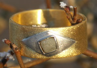 Zuiver gouden ring, met platina schuine ruit met daarin, ook in schuine ruitvorm, een ruwe diamant gezet.