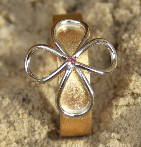 Gouden ring met dubbele lemniscaat in platina, in het centrum een roze briljant
