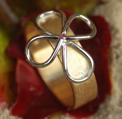 Gouden ring met dubbele lemniscaat in platina, in het centrum een roze briljant