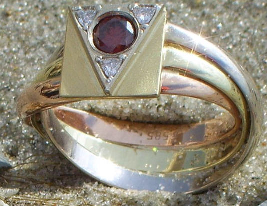 driekleur gouden Lemurië-ring met in de driehoek de zeldzame rode briljant die geflankeerd wordt door drie triljanten..